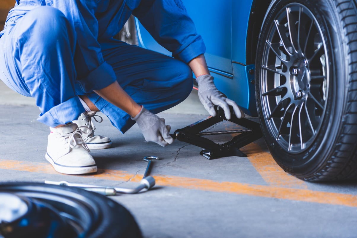 Car Mechanics Changing Tire at Auto Repair Shop 